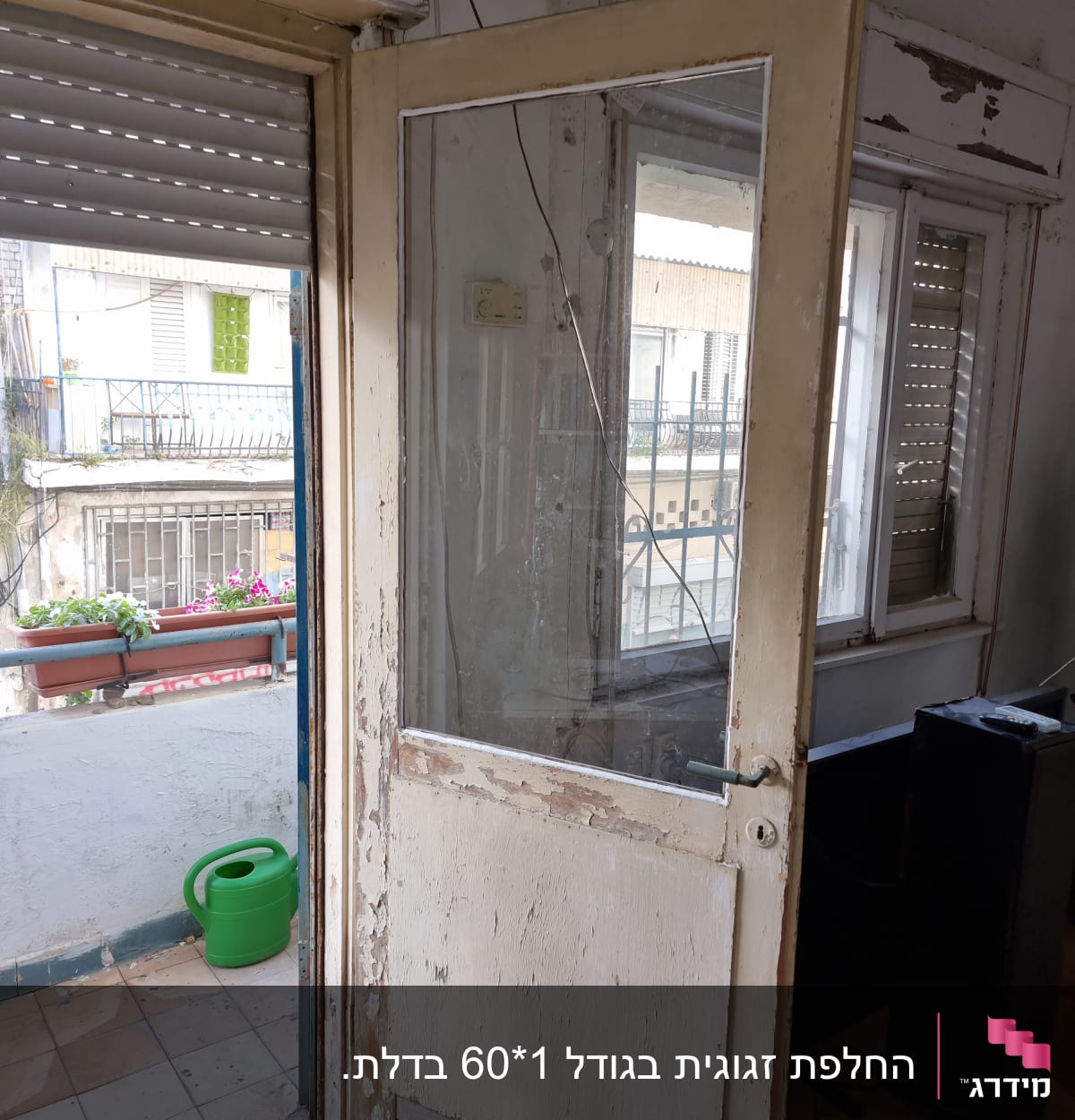 דלת זכוכית ישנה עם מסגרת עץ מתקלפת